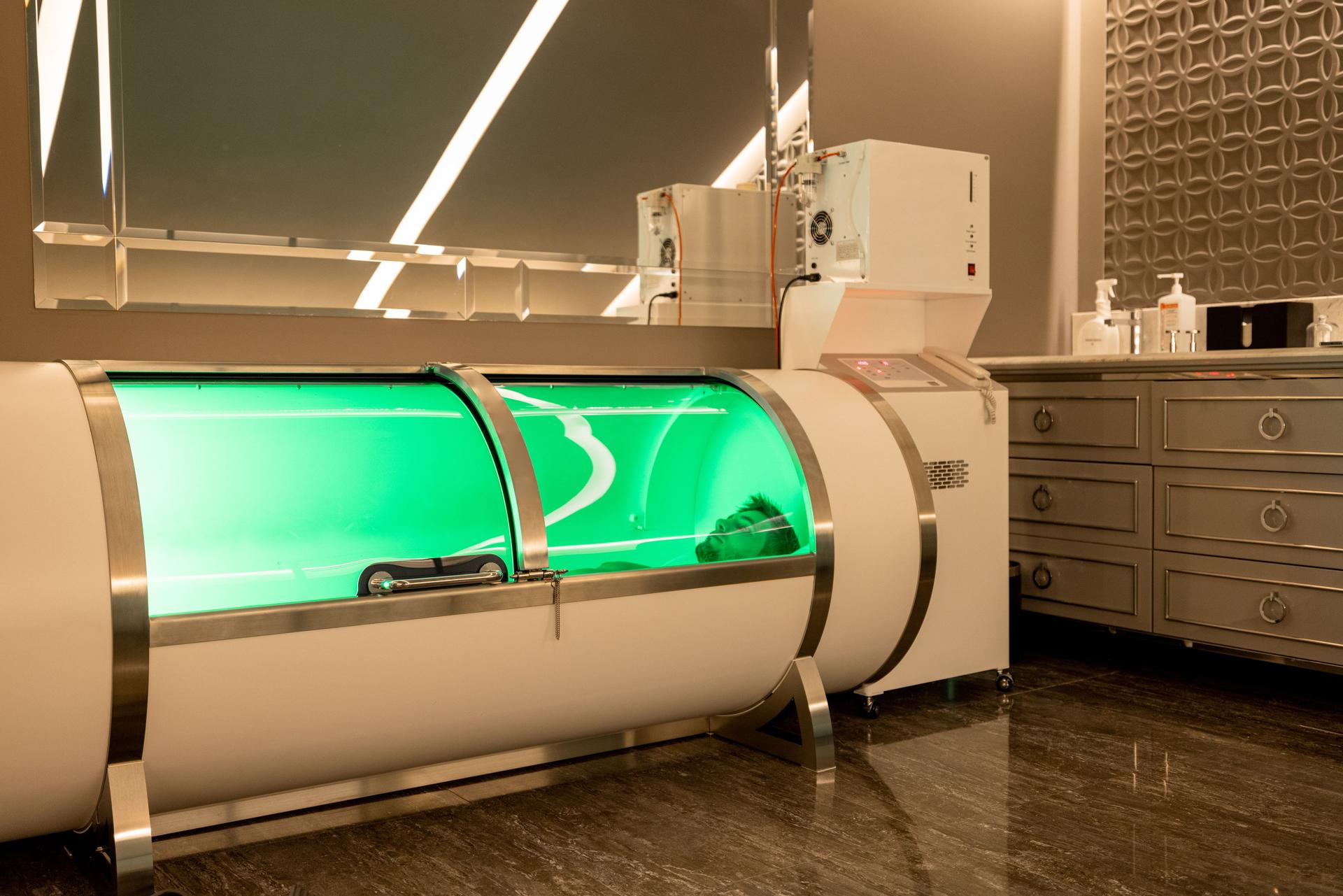Man lying in oxygen capsule in medical office
